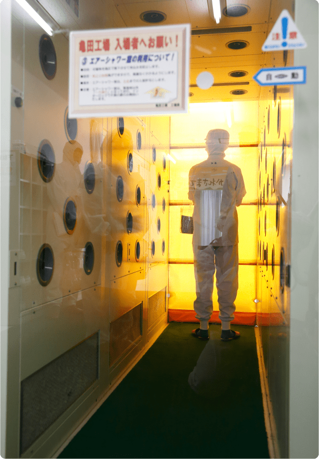 An employee wearing a specialist uniform enters an air shower