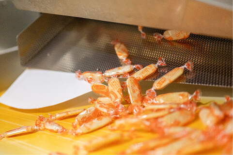 出来上がったハッピーターンが機械から出てくる様子